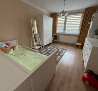 Dětský pokoj s podlahou s dřevěným dekorem ve 4-pokojovém bytě, s bílým nábytkem.