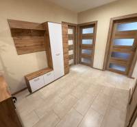 Předsíň s dřevěným nábytkem a podlahou s dřevěným dekorem ve 4pokojovém bytě.