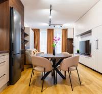 Interiér 1-pokojového bytu s podlahou s dřevěným dekorem, kuchyní a jídelním stolem.