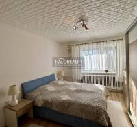 Světlá ložnice se stropním světlem a podlahou s dřevěným dekorem v 2-pokojovém bytě.