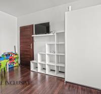 Dětský pokoj s patrovou postelí a úložnými prostory, podlaha s dřevěným dekorem.