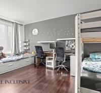 Dětský pokoj v 3-pokojovém bytě s palandou, stolem a podlahou s dřevěným dekorem.