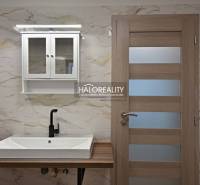 Koupelna s umyvadlem, černou vodovodní baterií a skříňkou v rodinném domě.