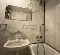 Koupelna ve 3-pokojovém bytě s vanou, zrcadlem a bílým umyvadlem.