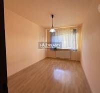 Prázdná místnost s oknem, závěsem, podlahou s dřevěným dekorem, světlem a radiátorem.