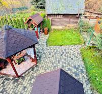 Zahradní altány u Chaty v Partizánskem obklopuje zeleň a dlážděné chodníky.