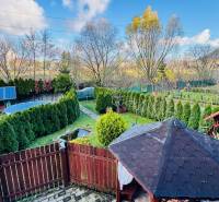 Zahrada u chaty v Partizánském s altánkem, solárními panely a bazénem.