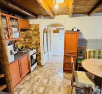 Rustikální kuchyně v chatě s dřevěným dekorem podlahy a dřevěným stropem.