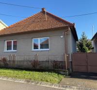 Rodinný dům v Machulincích s červenou taškovou střechou, bílými okny a zahrádkou.