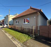 Ulice s rodinným domem v Machulincích, obloha je jasná a slunečná.