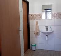 Kanceláře s umyvadlem, zrcadlem a podlahou s dřevěným dekorem.