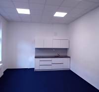 Kanceláře s modrou podlahou a kuchyňskou linkou.