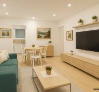 Obývací pokoj ve 4pokojovém bytě s podlahou s dřevěným dekorem, pohovkou a stolkem.