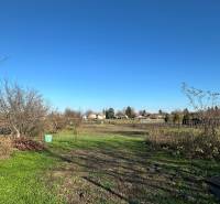 Rodinný dům na Podzáhradní ulici v Iži s velkou zahradou a stromy.