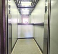 Výtah s kovovými stěnami a stropem se světly ve 3-pokojovém bytě.