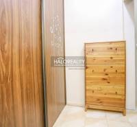 Chodba se skříní a komodou ve 2-pokojovém bytě s dlažbou.