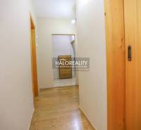 Chodba v 2-pokojovém bytě s podlahou s dřevěným dekorem a vestavěnými skříněmi.