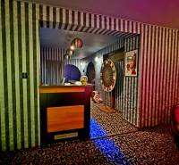 Interiér budovy s černobílými pruhovanými tapetami a vzorovaným kobercem.