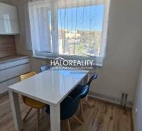 Jídelní kout s oknem v 2-pokojovém bytě a podlahou s dřevěným dekorem.