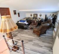 Obývací pokoj s dřevěným dekorem a rustikálním zařízením v rodinném domě.