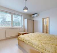 Světlá ložnice s postelí, psacím stolem a koupelnou v bytě s 5 a více pokoji.