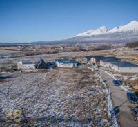 Pozemky na bydlení v Mlynici s rozestavěnými domy a zasněženou krajinou.