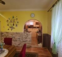 Jídelna v rodinném domě s obloukovým průchodem a podlahou s dřevěným dekorem.