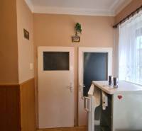 Interiér rodinného domu se dvěma dveřmi, lednicí a podlahou s dřevěným dekorem.