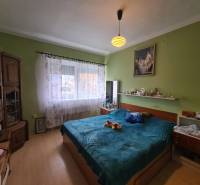 Ložnice v rodinném domě s podlahou s dřevěným dekorem a postelí.