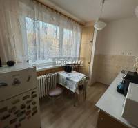 Kuchyně v 2-pokojovém bytě s podlahou s dřevěným dekorem a tradičním vybavením.