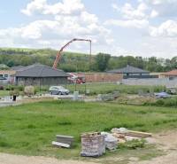 Pozemky - bydlení v Modrovce; vidět rozestavěné domy a stavební materiál.