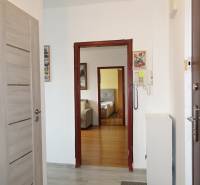 Chodba v 3-pokojovém bytě s podlahou s dřevěným dekorem a interkomem.