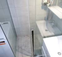 Koupelna se sprchovým koutem a pračkou v 3-pokojovém bytě.