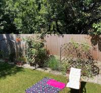 Zahrada 4pokojového bytu v Bratislavě - Vrakuni s křeslem a kobercem na trávě.