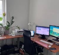 Domácí kancelář s počítačem a podlahou s dřevěným dekorem ve 4-pokojovém bytě.