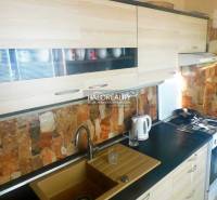 Pokoj v 2-pokojovém bytě s podlahou s dřevěným dekorem, televizorem a vestavěnými skříněmi.