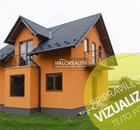 Oranžový rodinný dům v Sadech nad Torysou se šikmou střechou a venkovním balkonem.