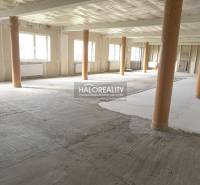 Obchodní prostory s otevřeným prostorem a odhalenými dřevěnými sloupy.