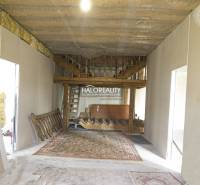 Interiér obchodních prostor s dřevěným schodištěm a kobercem.