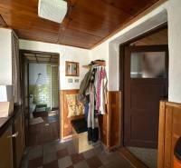 Interiér rodinného domu se vstupem do koupelny a věšáky na oblečení.