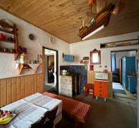 Interiér rodinného domu s dřevěným stropem a rustikálním vybavením.