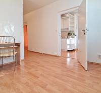 Pokoj v 2-pokojovém bytě s podlahou s dřevěným dekorem, pracovním stolem a židlí.