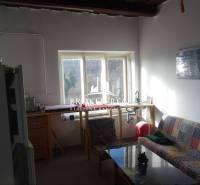 Obývací pokoj s pohovkou a výhledem ven, Rodinný dům s jednoduchým zařízením.