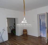 Obývací prostor v rodinném domě s podlahou s dřevěným dekorem a bílými stěnami.