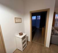 Interiér 2-pokojového bytu s podlahou s dřevěným dekorem, světlý nábytek a dekorace.