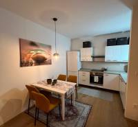 Kuchyně a jídelna v 2-pokojovém bytě s podlahou s dřevěným dekorem.