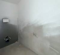 Neúplně zařízená koupelna v rodinném domě, připravená na instalaci sanitárních zařízení.