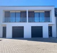 Rodinný dům na Polnokesovské ulici v Mojmírovicích se skleněným balkonem a dvojgaráží.