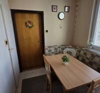 Jídelní kout se stolem a lavicemi ve 3pokojovém bytě.