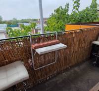 Balkon 3pokojového bytu v Galantě s moderním zábradlím a bílými barovými židlemi.